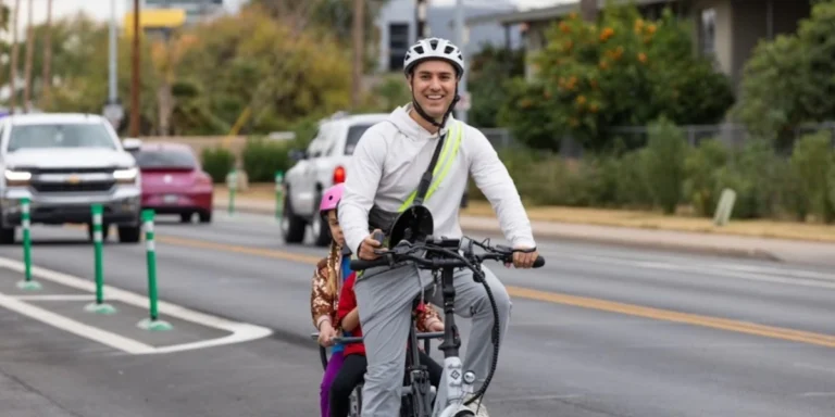 Urbanist Ed Hermes bikes with his children on a protected bike lane in Phoenix, promoting safer streets and bike-friendly infrastructure.