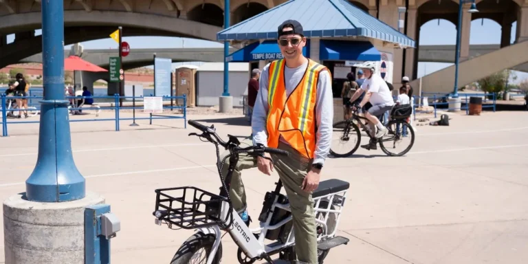 Jack Ketcham at Tempe Town Lake on a white Lectric bike wearing an orange vest